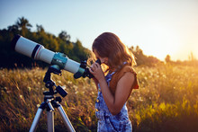 Little Girl Using Telescope In Nature To Explore The Universe.