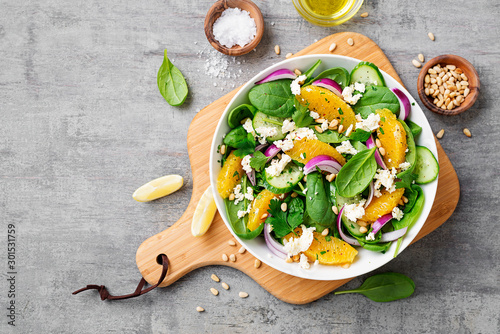 Fresh spinach salad with oranges, feta (ricotta) cheese, red onion and pine nuts Tableau sur Toile