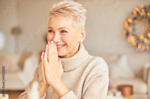 Indoor Shot Of Overjoyed Cheerful Mature Short Haired Woman In