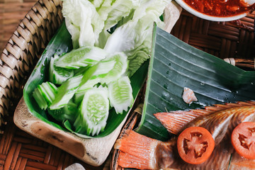 Set of local food at Na Ton Chan homestay,fried fish with tomato,corn,cucumber and boil vegetable  Si Satchanalai district, Sukhothai Province ,Thailand.on Khantoke traditionally meal set popular