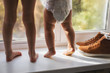 Children's bare feet. Sisters with flat feet on a white background, looking out the window, indoors