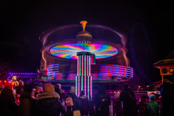 Wall Mural - A blurry colorful carousel in motion at the amusement park, night illumination. Long exposure.