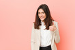 © Asier - Young brunette business woman against a pink background smiling and raising thumb up