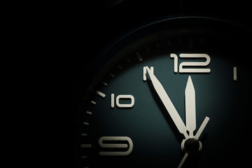 dial of a clock showing five minutes to twelve