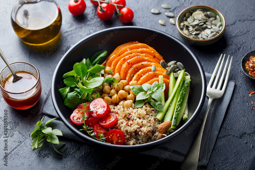 Healthy vegetarian salad. Roasted pumpkin, quinoa, tomatoes, green salad. Buddha bowl. Slate background. Close up. - obrazy, fototapety, plakaty 