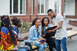 © AS Photo Family - Group of five african college students spending time together on campus at university yard. Black afro friends studying at bench with school items, laptops notebooks.