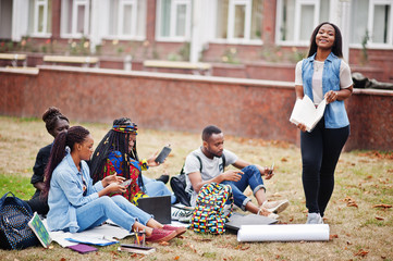 Wall Mural - Group of five african college students spending time together on campus at university yard. Black afro friends studying. Education theme.