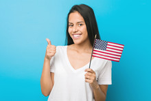 Young Hispanic Woman Holding A United States Flag Smiling And Raising Thumb Up