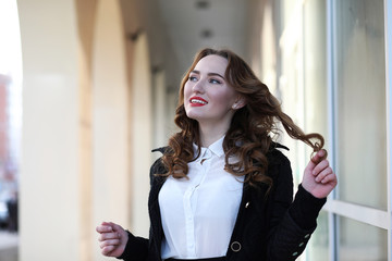 Wall Mural - Business lady in strict clothes on the background of buildings