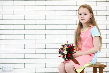 little girl is sitting on a chair