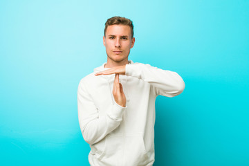 Sticker - Young caucasian sport man showing a timeout gesture.