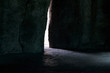 Narrow light ray between stones in cave. Hidden exit