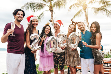 Wall Mural - Friends celebrating Christmas or New Year eve at the beach.