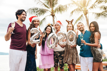 Wall Mural - Friends celebrating Christmas or New Year eve at the beach.