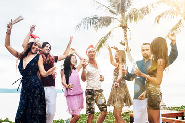 Wall Mural - Friends celebrating Christmas or New Year eve at the beach.