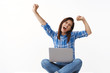 © Cookie Studio - Lucky ambitious carefree middle-aged successful woman feel relieved happy, yelling yeah waving hands up fist pump gesture, shout hooray, finish working, hold smartphone laptop, got vacation