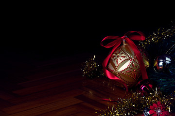 Beautiful christmas ornaments (Baubles, festoons) placed on a wooden floor in the corner of the frame, so that it later can be used as a text background.