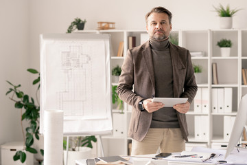 Poster - Architect with tablet standing by desk on background of sketch on whiteboard