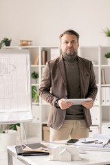 Poster - Confident mature architect in formalwear using tablet while standing by desk