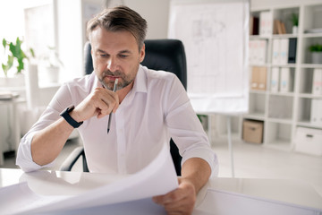 Aufkleber - Pensive engineer with pencil and paper looking at sketch while thinking of ideas