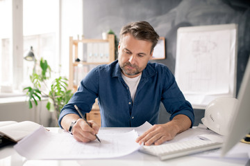 Aufkleber - Serious mature architect drawing new sketch on paper while sitting by desk