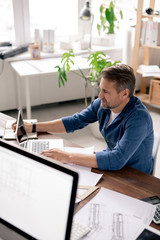 Aufkleber - Serious engineer looking at data on laptop display while surfing in the net