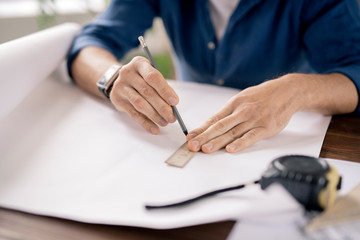 Poster - Hands of mature engineer holding pencil and ruler while drawing line on paper