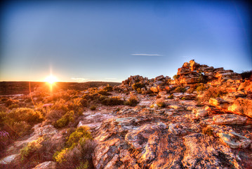 Sunrise behind rocky hill