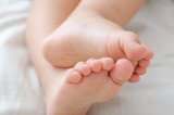 Fototapeta Koty - Legs of a two year old baby. The concept of healthy children's feet, legs. Soft focus, background.