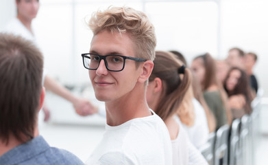 close up. smiling guy sitting in a row with his associates