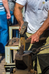 Wall Mural - blacksmith performs the forging of hot glowing metal on the anvil