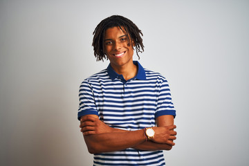 Afro man with dreadlocks wearing striped blue polo standing over isolated white background happy face smiling with crossed arms looking at the camera. Positive person.