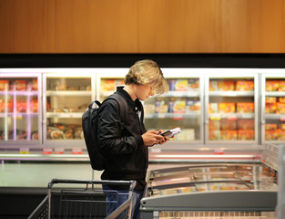 Man choosing frozen food from a supermarket freezer	