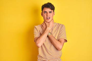 Wall Mural - Teenager boy wearing yellow t-shirt over isolated background shouting and suffocate because painful strangle. Health problem. Asphyxiate and suicide concept.