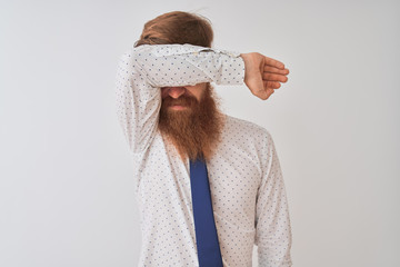 Poster - Young redhead irish businessman standing over isolated white background covering eyes with arm smiling cheerful and funny. Blind concept.