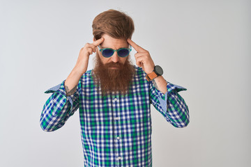 Canvas Print - Young redhead irish man wearing casual shirt and sunglasses over isolated white background with hand on head for pain in head because stress. Suffering migraine.