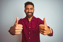 Young Indian Man Wearing Red Elegant Shirt Standing Over Isolated Grey Background Success Sign Doing Positive Gesture With Hand, Thumbs Up Smiling And Happy. Cheerful Expression And Winner Gesture.