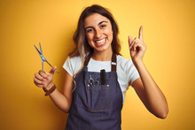 Young Beautiful Hairdresser Woman Holding Scissors Over Yellow Isolated Background Very Happy Pointing With Hand And Finger To The Side