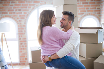 Wall Mural - Young beautiful couple hugging in love celebrating very happy moving to new apartment