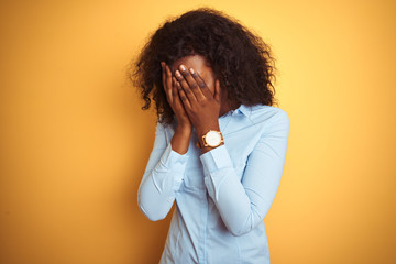 African american businesswoman wearing elegant shirt over isolated yellow background with sad expression covering face with hands while crying. Depression concept.