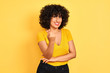 © Krakenimages.com - Young arab woman with curly hair wearing t-shirt standing over isolated yellow background Beckoning come here gesture with hand inviting welcoming happy and smiling