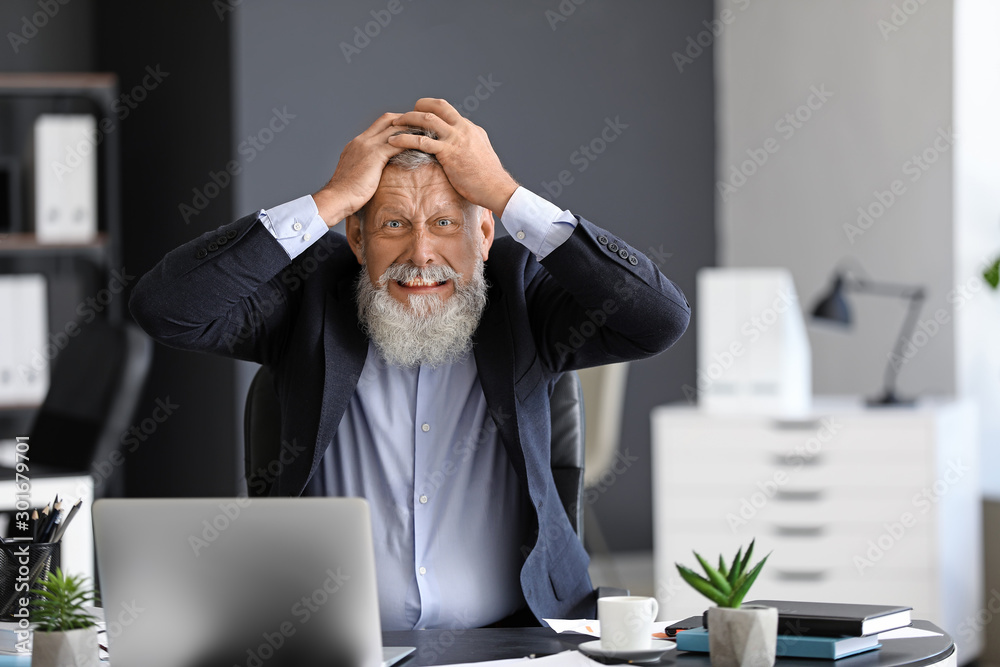 Angry mature man working in office