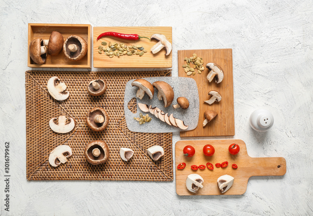 Composition with fresh champignon mushrooms on light background