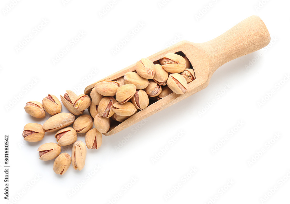 Scoop with tasty pistachio nuts isolated on white