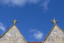 Two Crosses Sit Atop A Church Roof