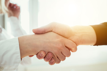 Shaking hands, concept for teamwork: Close up of man and woman shaking hands in the office