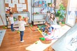 © Krakenimages.com - Beautiful teacher and group of toddlers playing around lots of toys at kindergarten