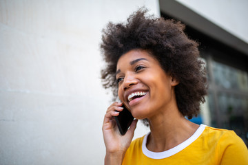 Close up of beautiful smiling african american woman talking on mobile phone