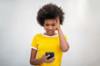 © mimagephotos - frustrated young black woman looking at cellphone with angry face