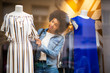 © mimagephotos - young black woman shopping for clothes in store